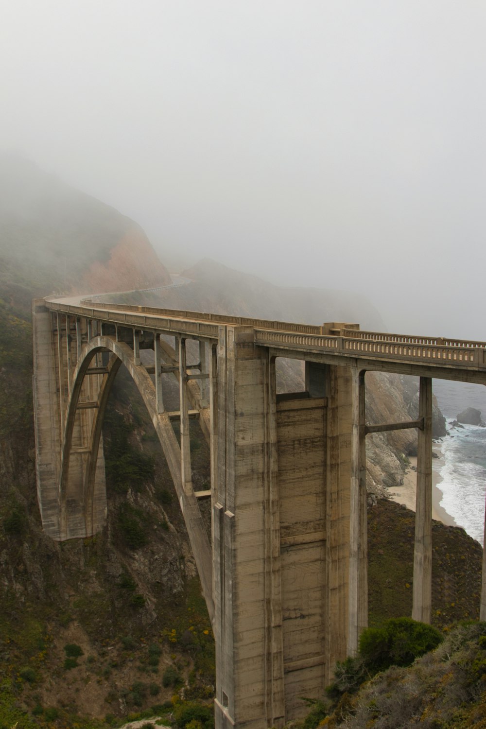 Un grande ponte su uno specchio d'acqua in una giornata nebbiosa
