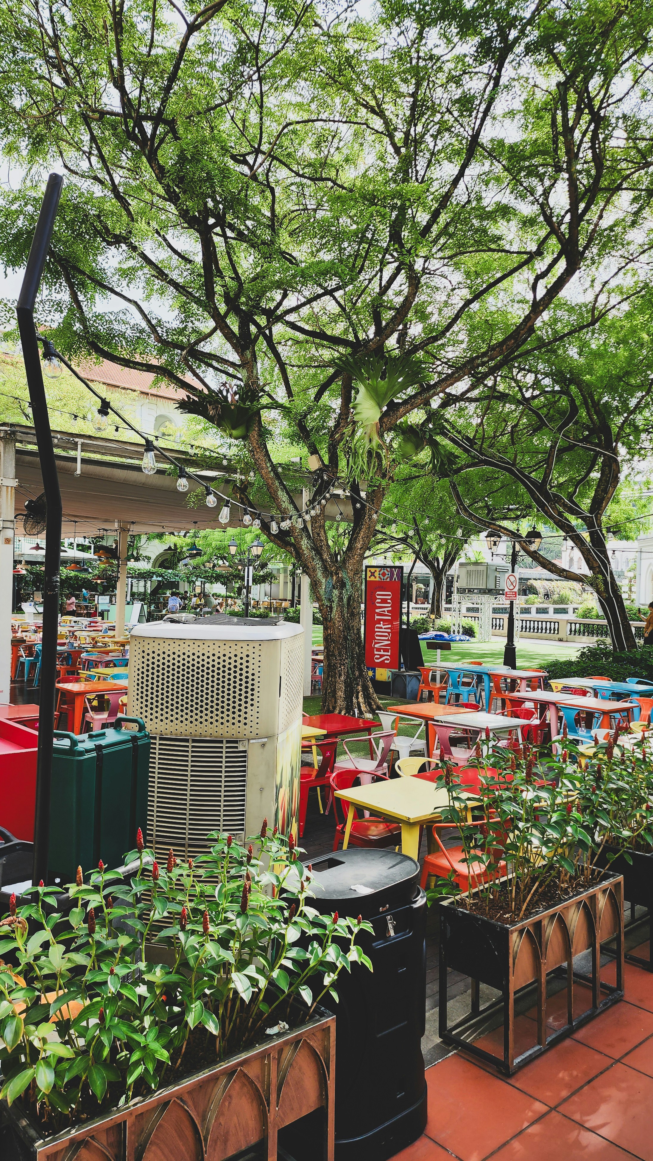 a patio with tables, chairs, and air conditioner