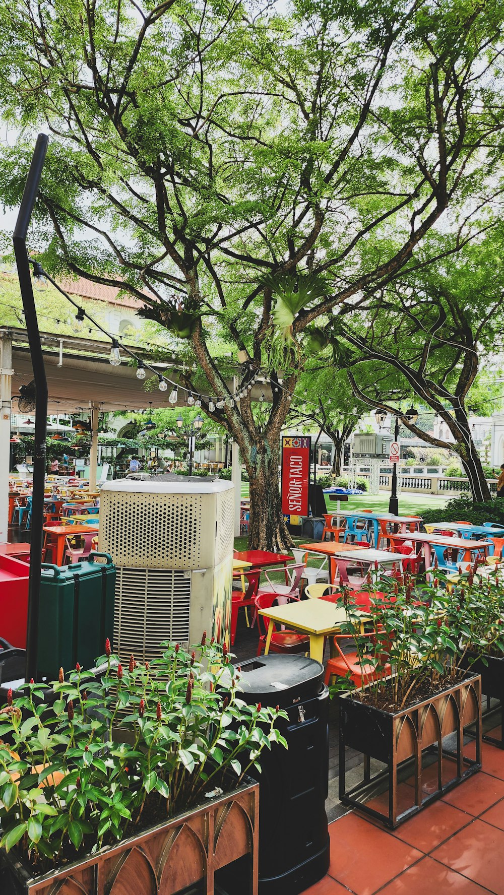 a patio with tables, chairs, and air conditioner