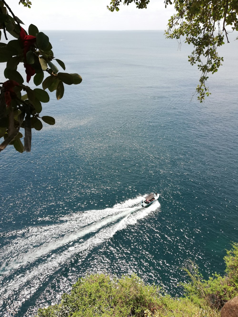 a boat traveling on the water near a cliff