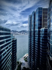 a couple of tall buildings sitting next to a body of water