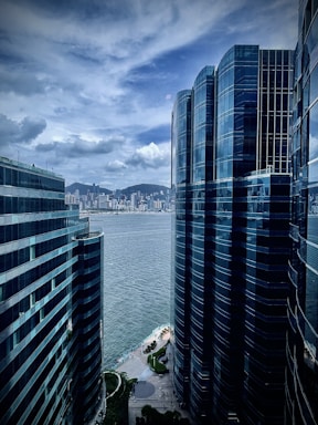 a couple of tall buildings sitting next to a body of water
