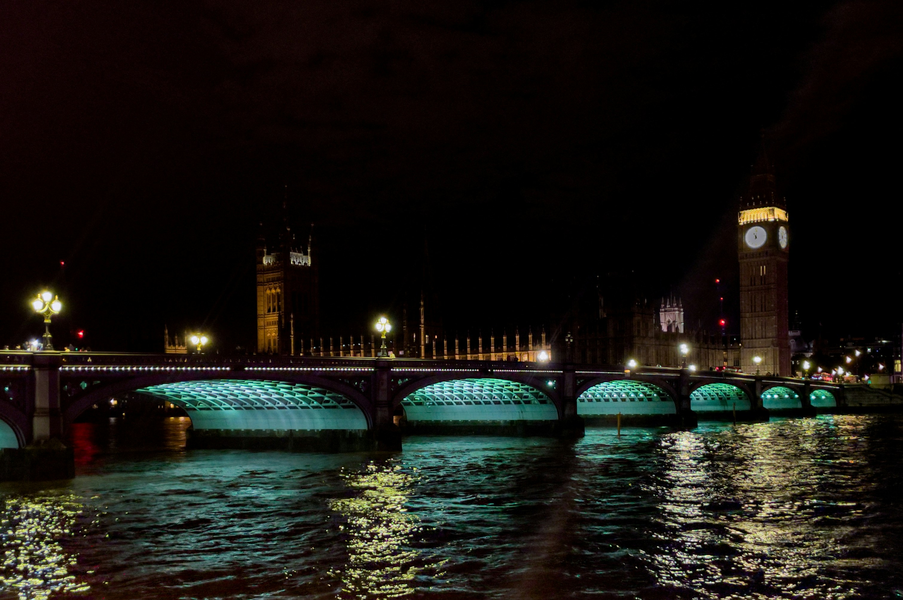 a bridge over a river with a clock tower in the background, 