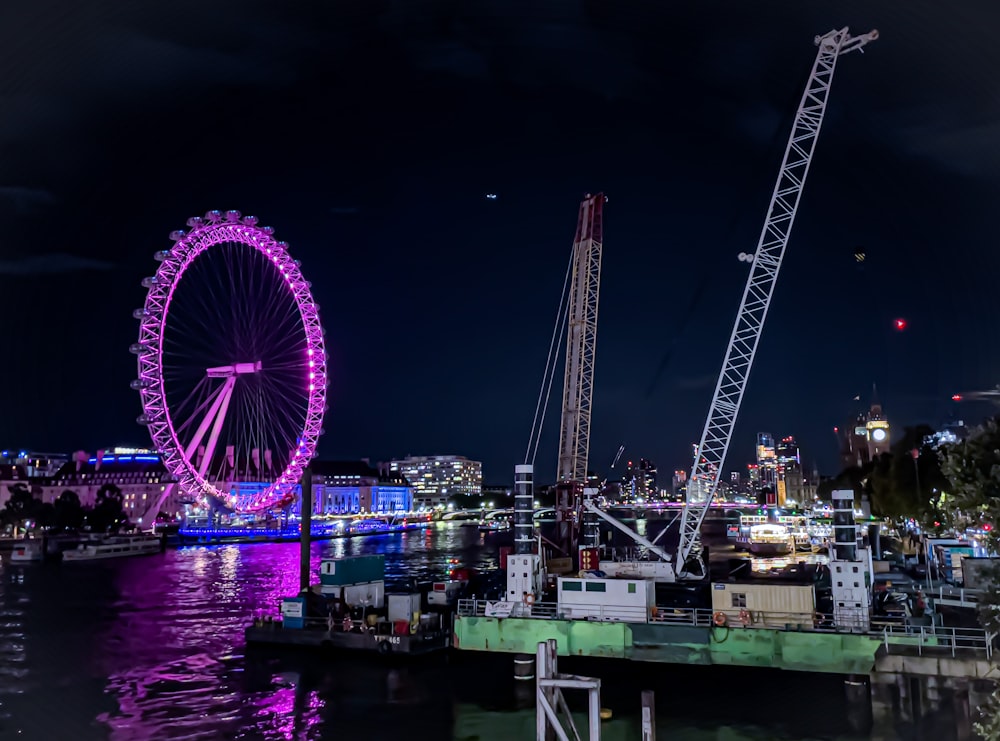 a large ferris wheel sitting next to a body of water