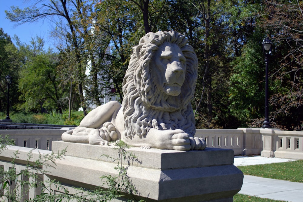 a statue of a lion sitting on top of a stone bench