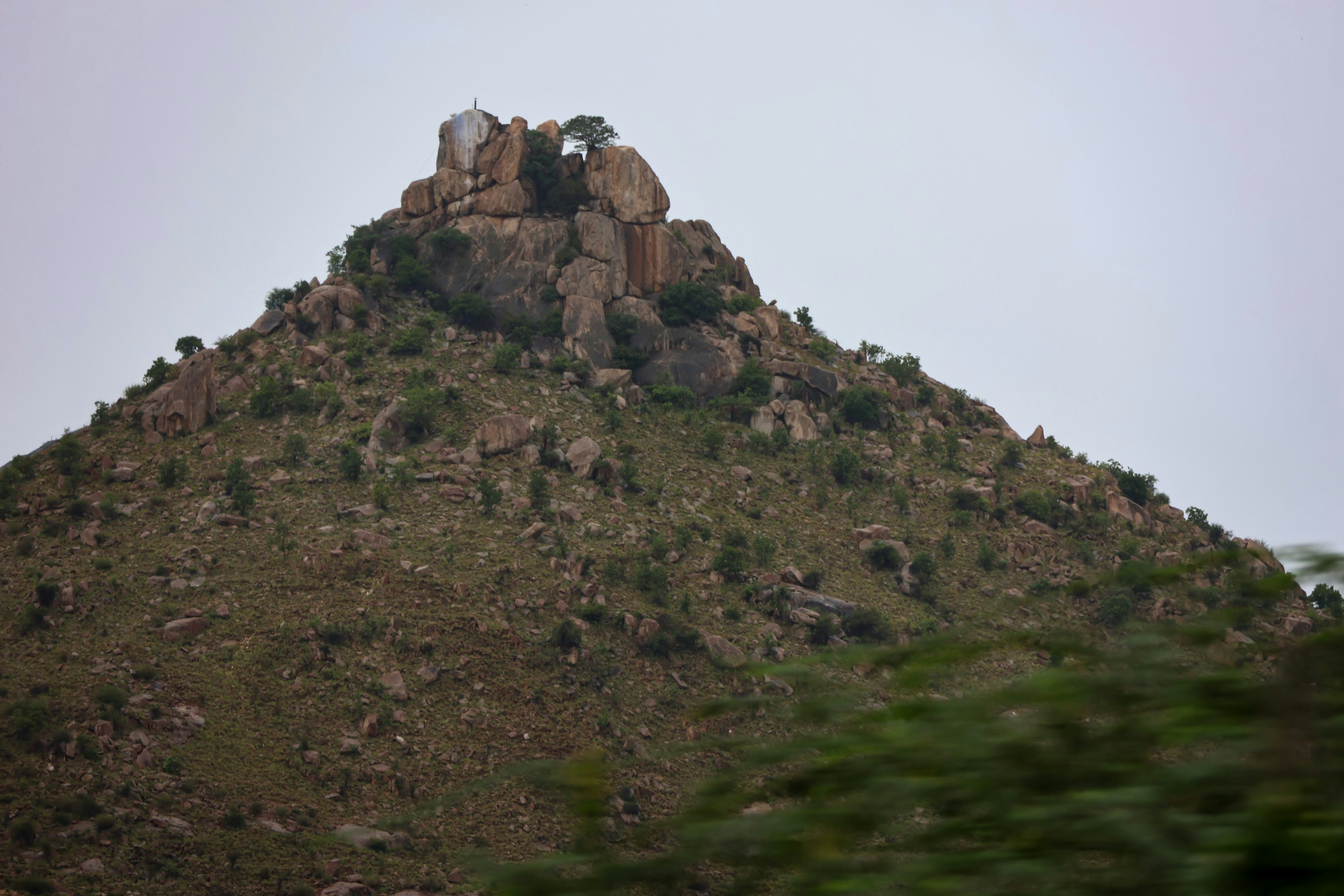 a hill with a rock formation on top of it