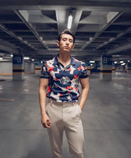 Confident lead standing in a clean parking garage pointing at a discreet indoor DAS unit mounted on a concrete beam.