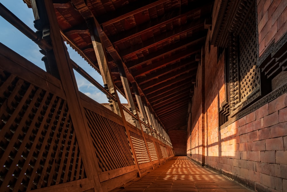 a wooden walkway leading to a building with a wooden roof
