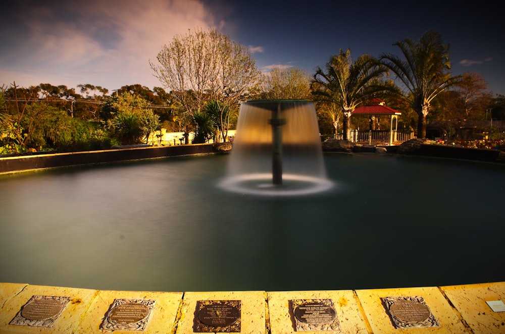 a fountain in the middle of a park at night