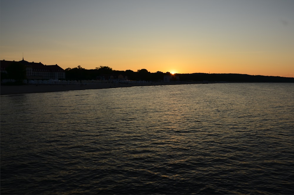 the sun is setting over a body of water