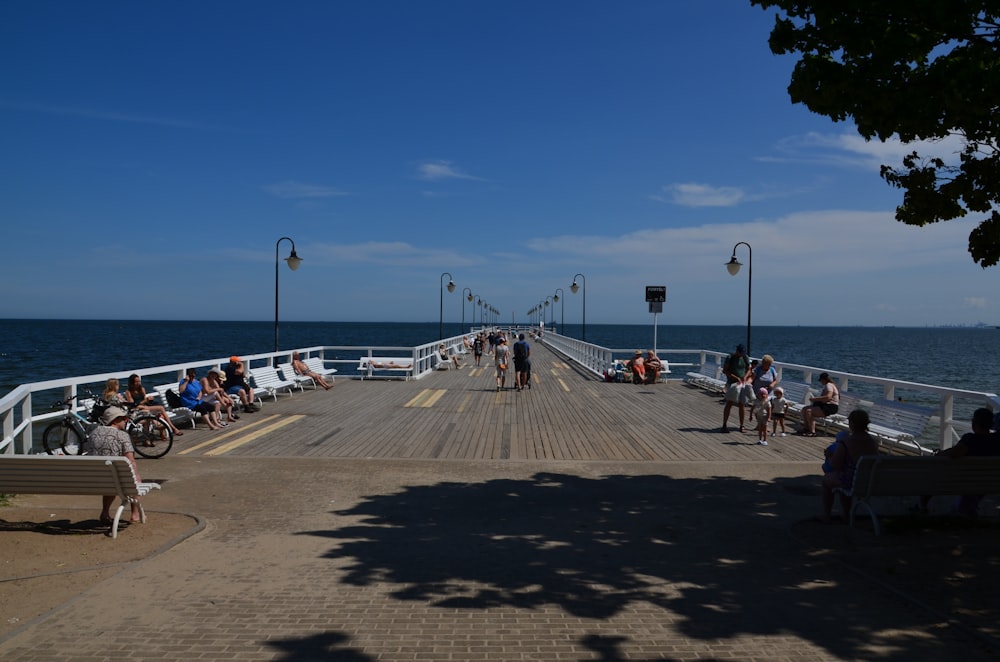 a group of people sitting on top of a pier