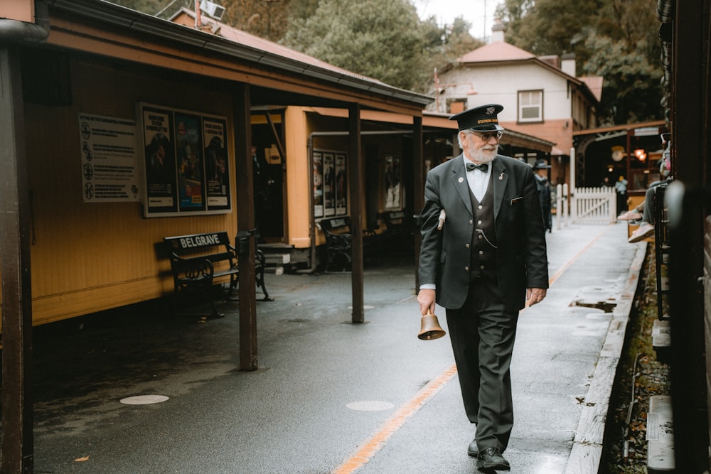 a man in a suit and tie walking down a street