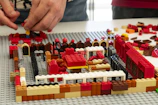Close-up of hands assembling a complex Lego castle.