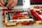Close-up of hands assembling colorful LEGO bricks on a wooden table.