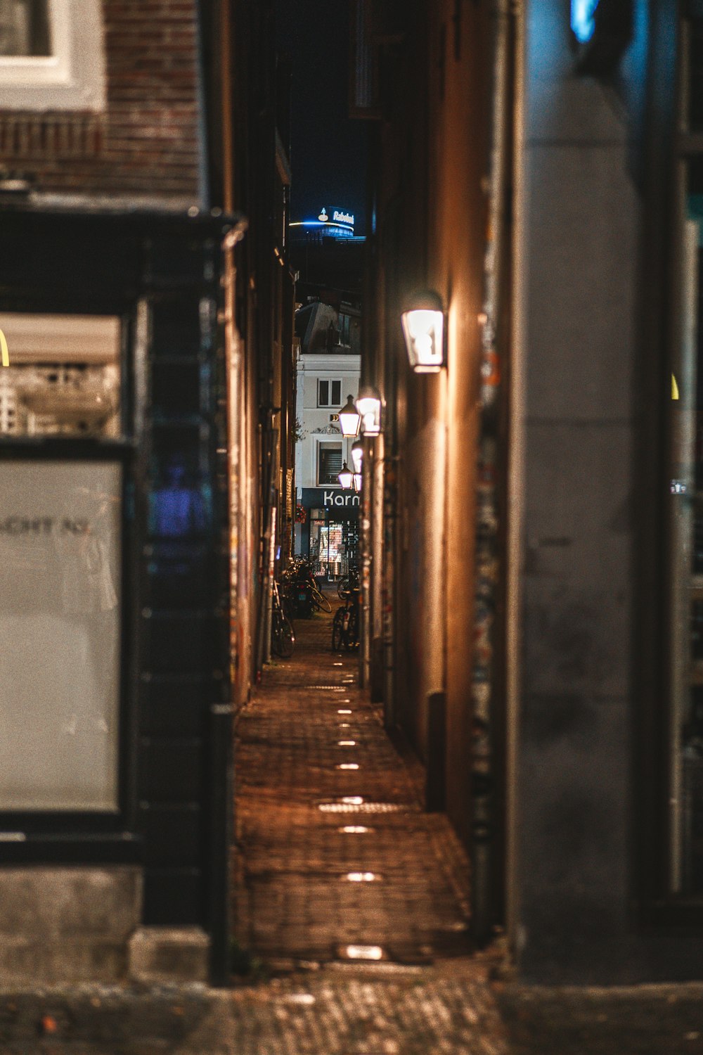 a narrow alley way with a clock on the wall