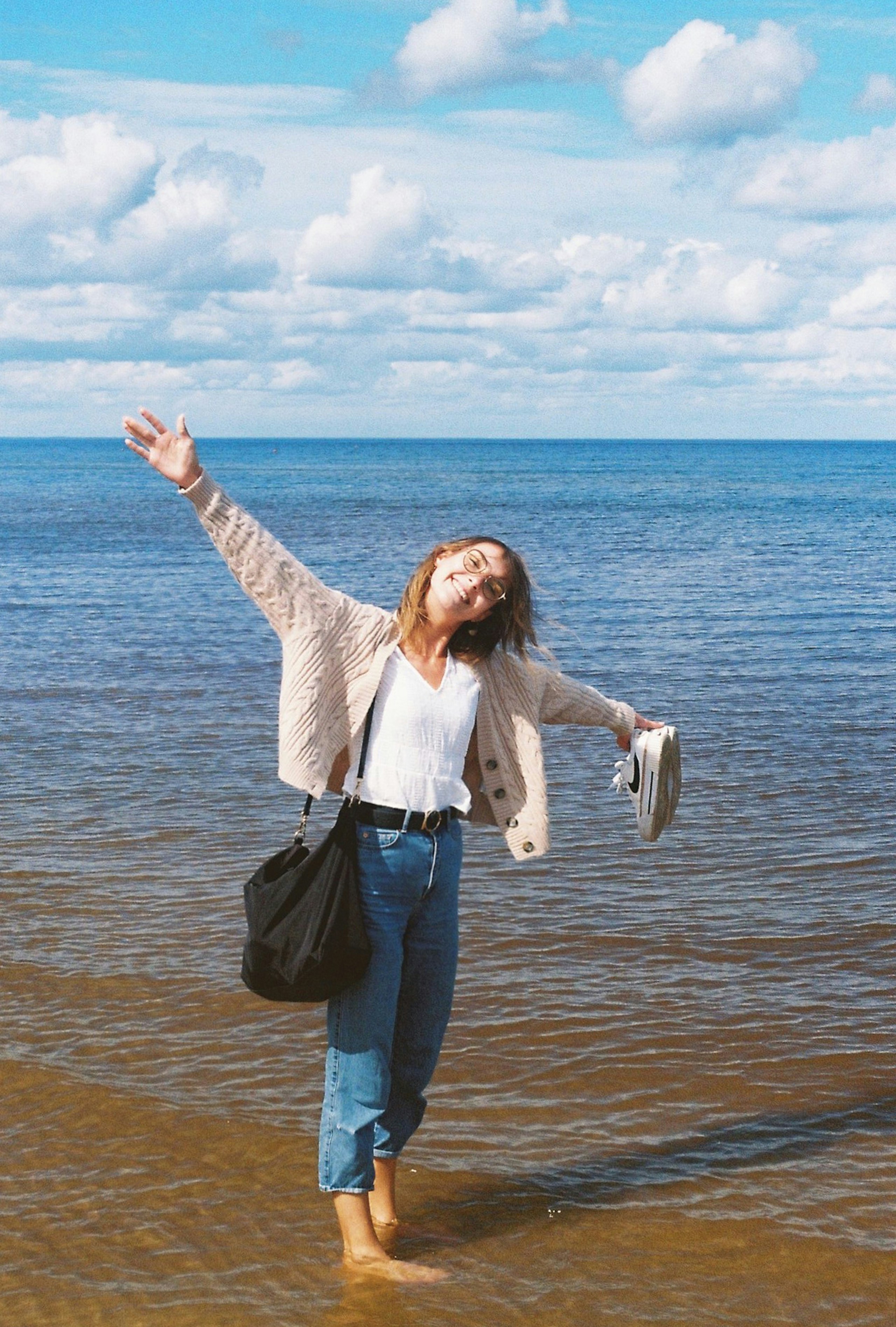 a woman standing on top of a beach next to the ocean