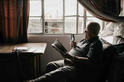 a man sitting in a chair holding a magnifying glass