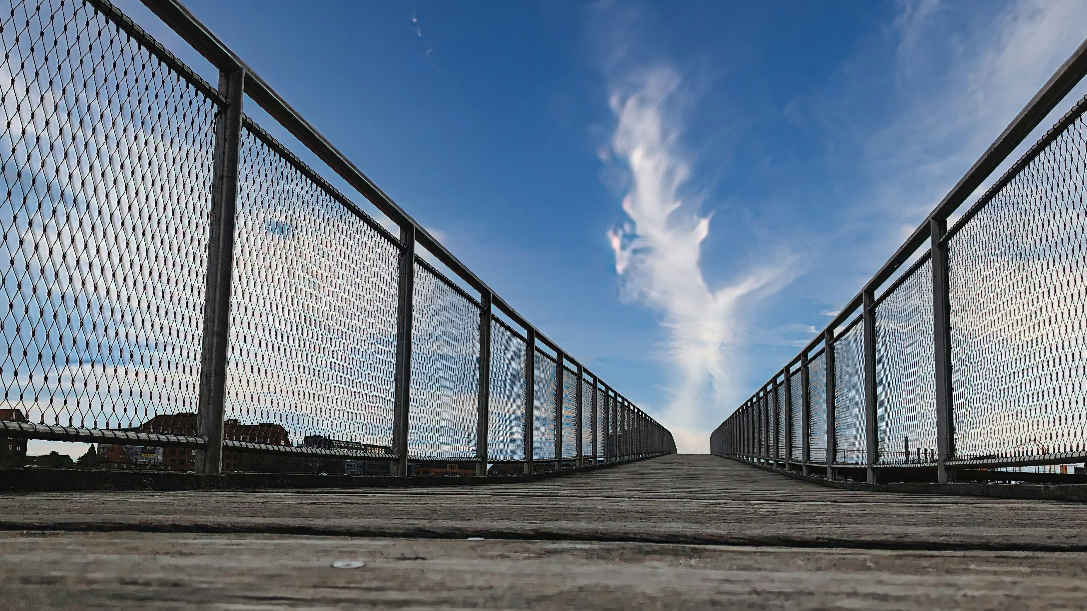 a wooden walkway with a sky background