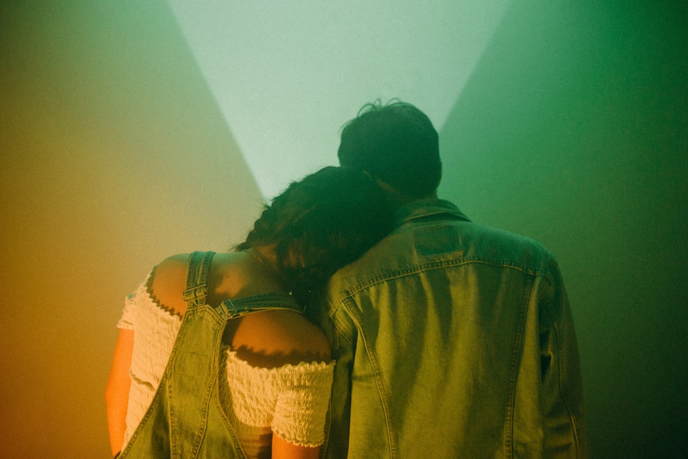 a man and a woman standing in front of a green light