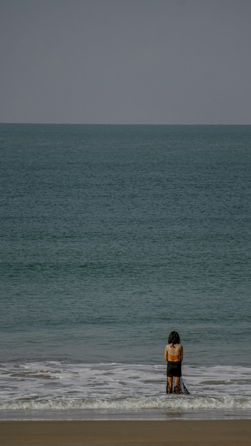 a person standing on a beach next to the ocean