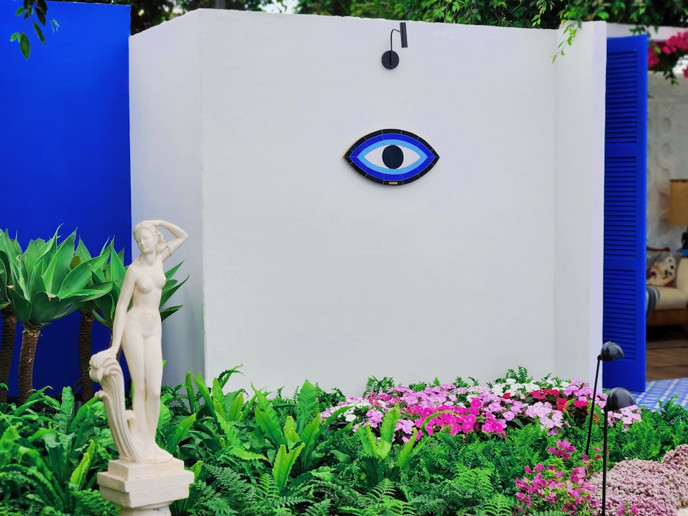 a garden with a statue of a woman and a blue eye