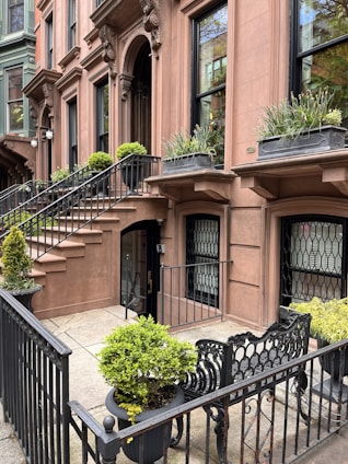 A friendly agent handing keys to a happy renter in front of a classic NYC brownstone building.