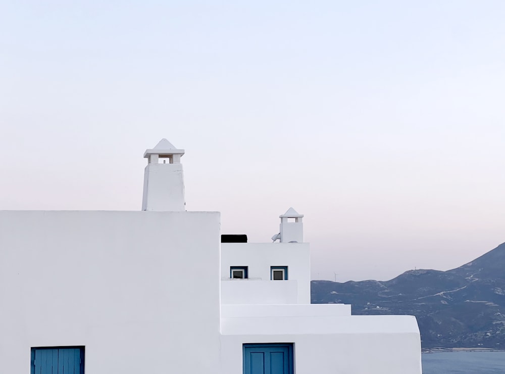 a white building with blue doors and a bell tower