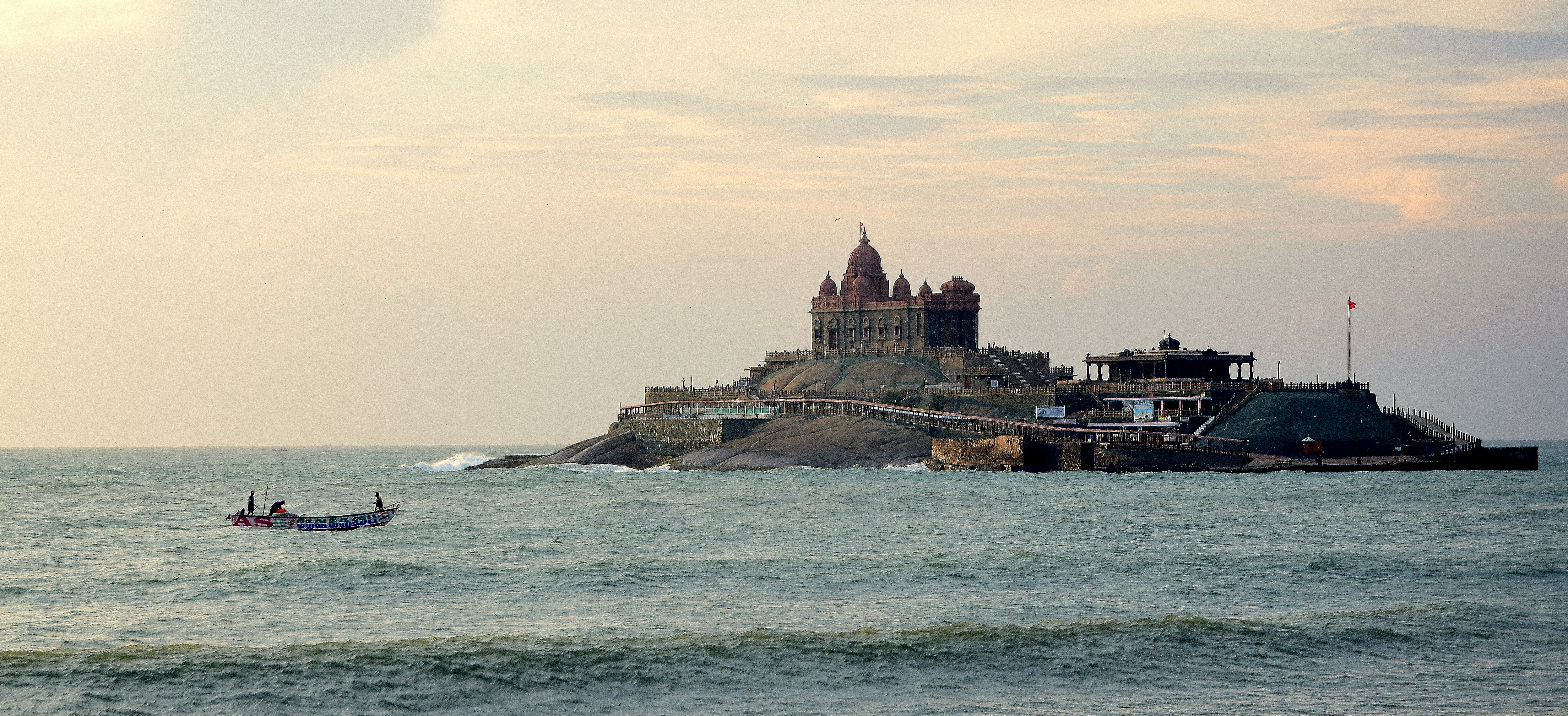 a small boat is in the water near a castle