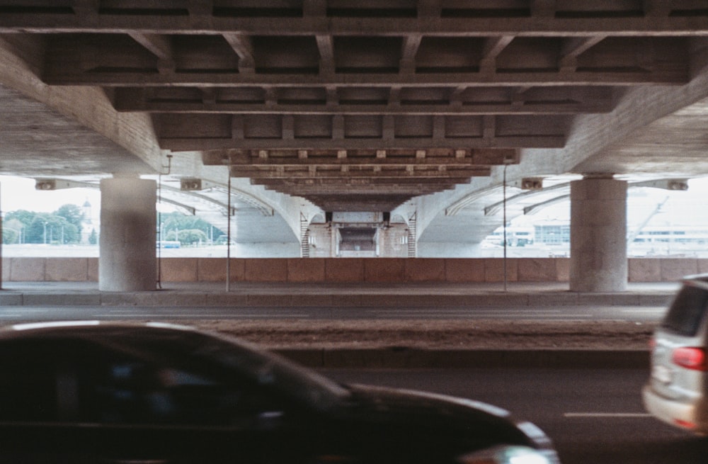 a car is driving under an overpass in a parking lot