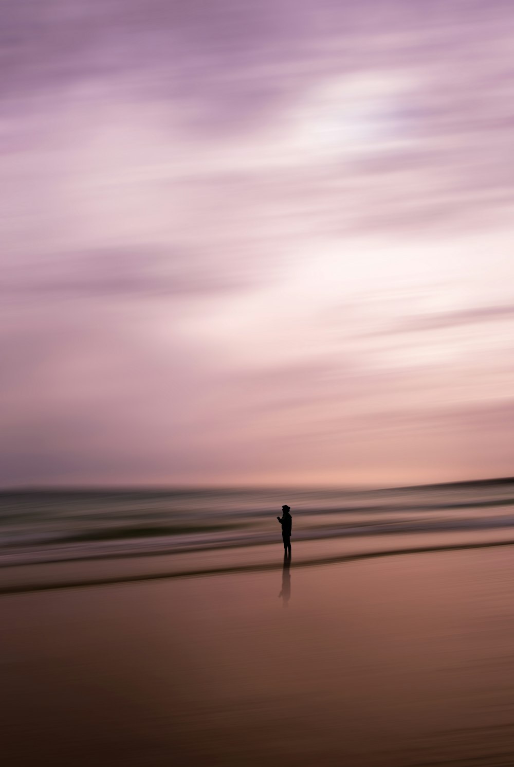 une personne debout sur une plage près de l’océan