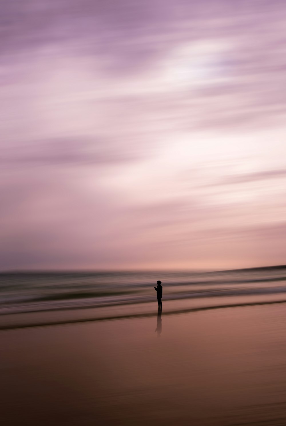 a person standing on a beach near the ocean