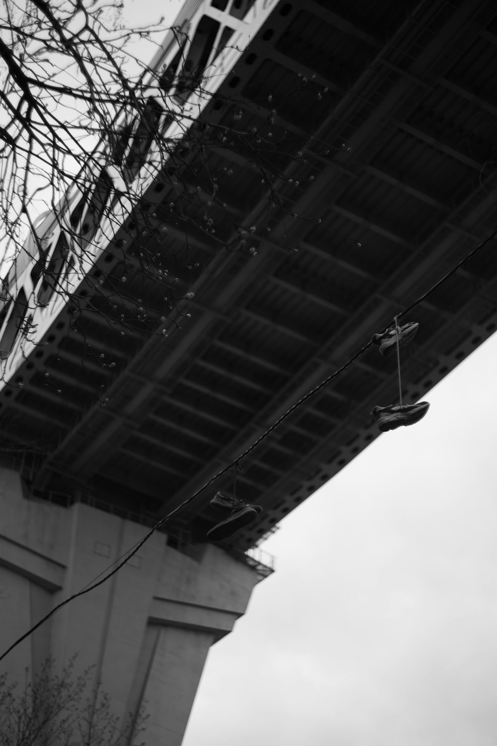 a black and white photo of a pair of shoes hanging off the side of a