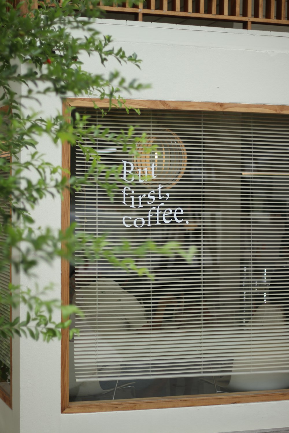 a window with a sign that reads, put first coffee