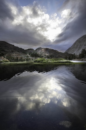 A scenic mountain landscape with a serene lake in the foreground.