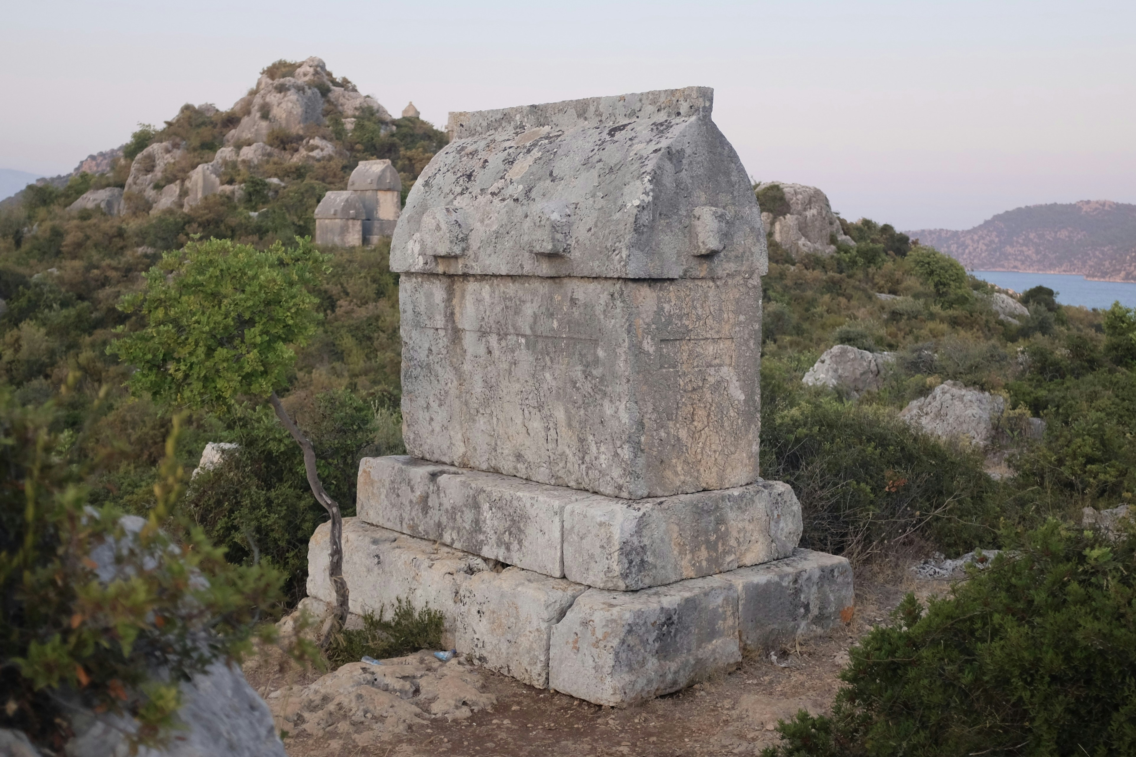a large stone structure sitting on top of a lush green hillside