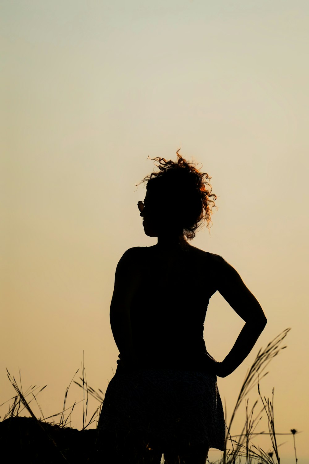 a silhouette of a woman with her hands on her hips