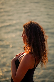 a woman standing in front of a body of water