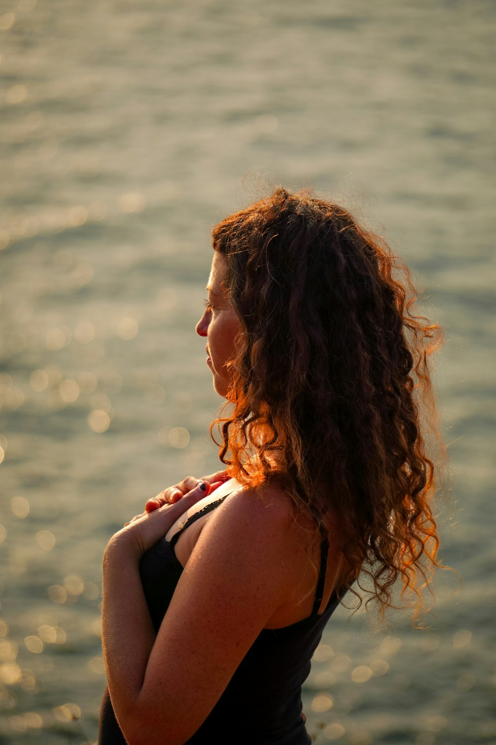 a woman standing in front of a body of water