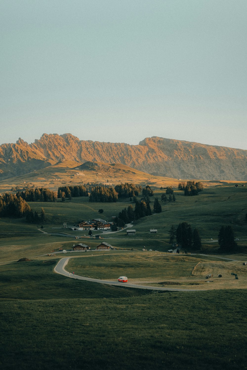 a scenic view of a rural area with mountains in the background