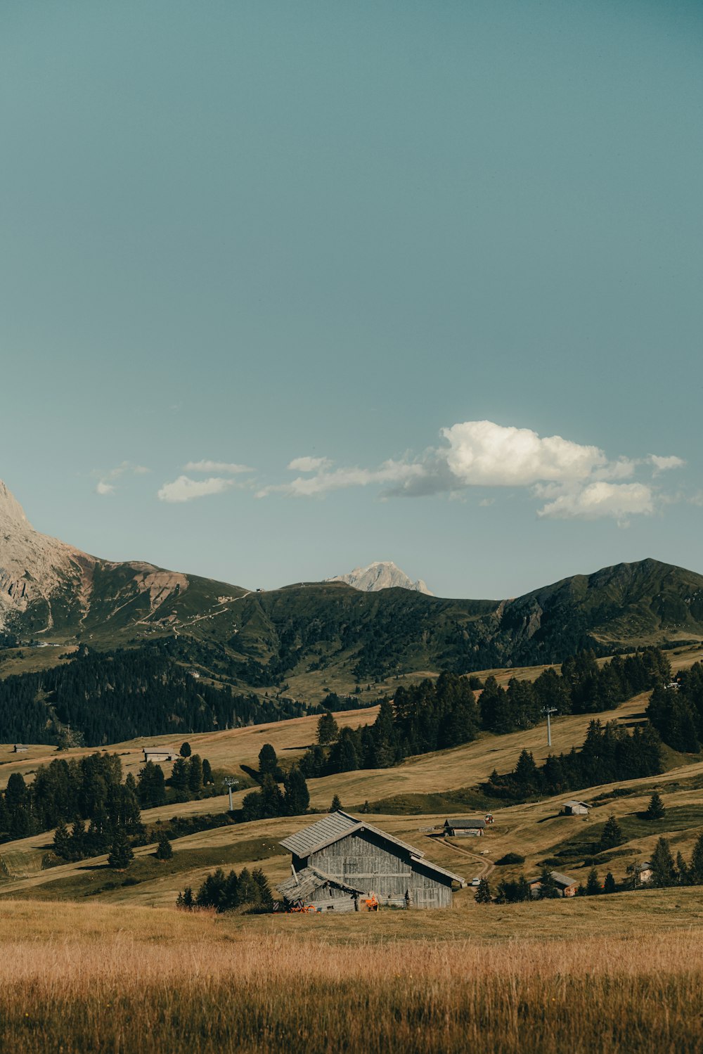 a mountain range with a barn in the foreground