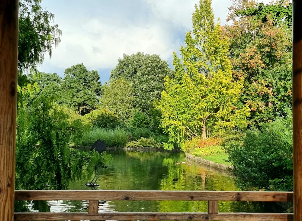 a view of a lake through a wooden fence