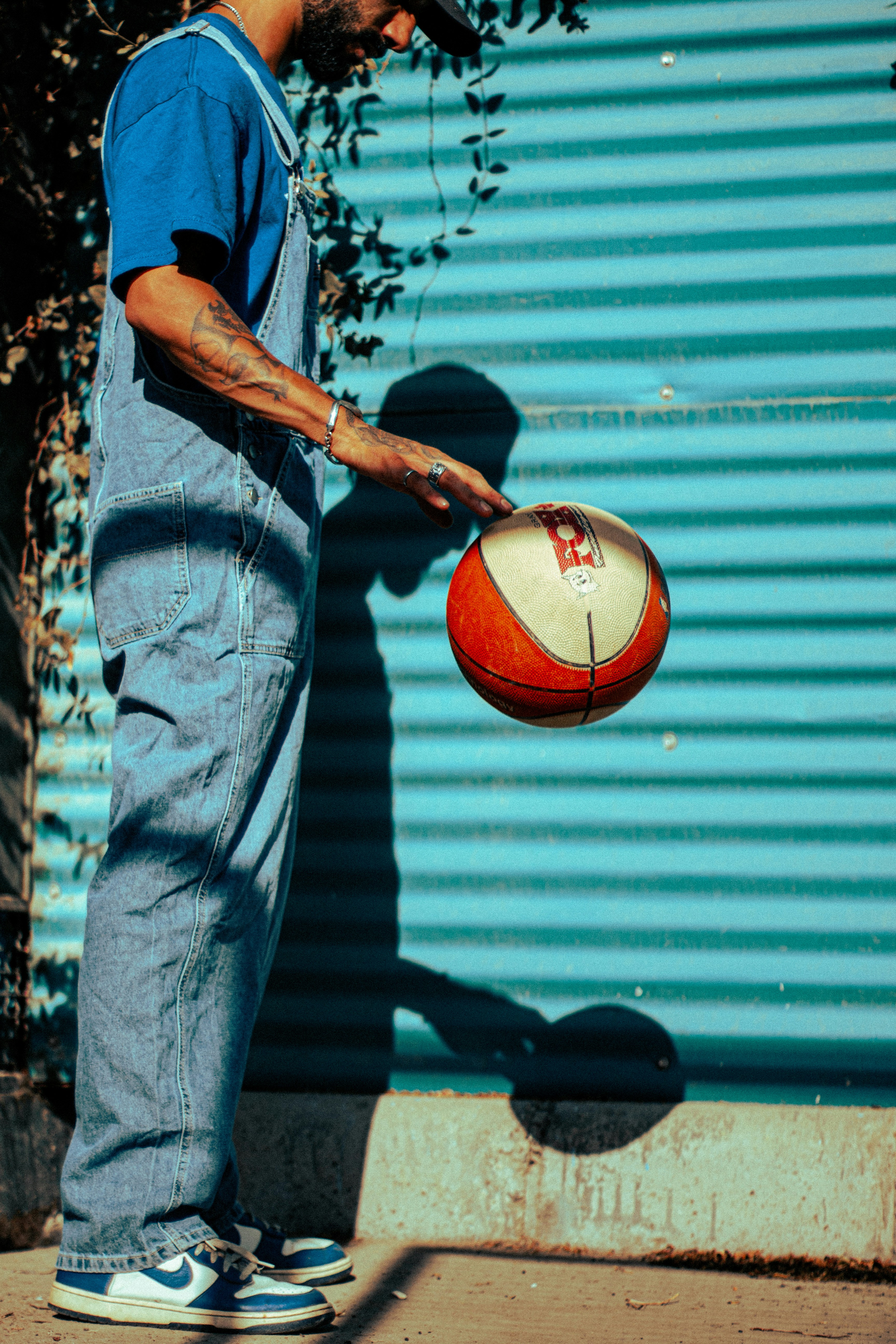 a man in overalls holding a red and white ball