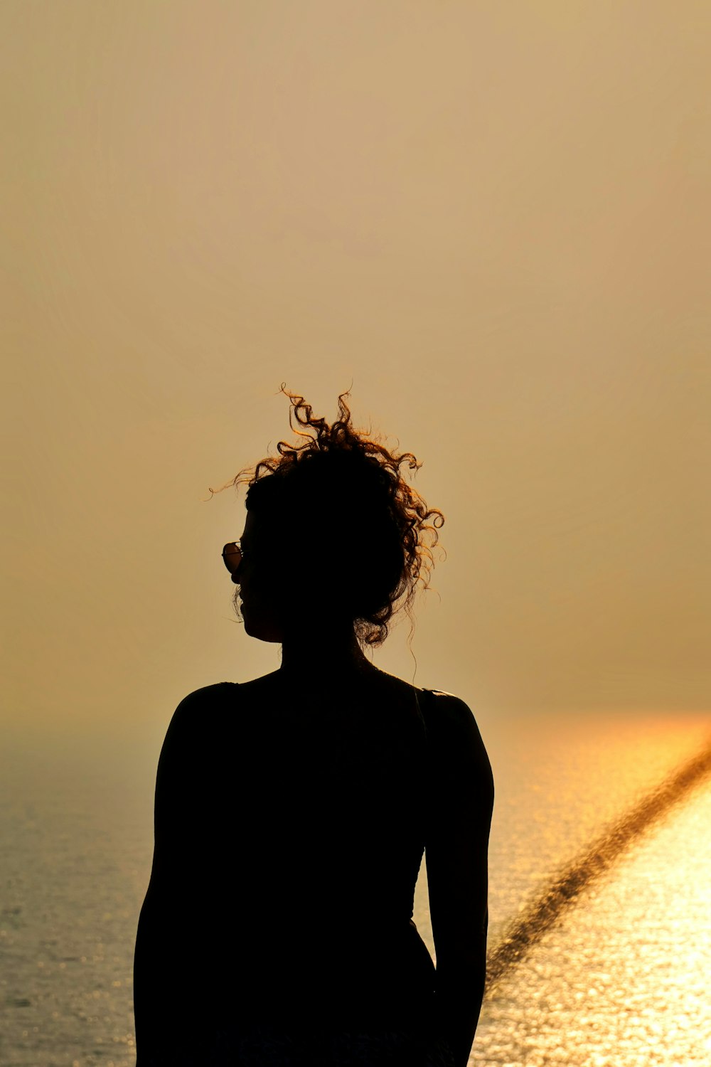 a woman standing in front of a body of water