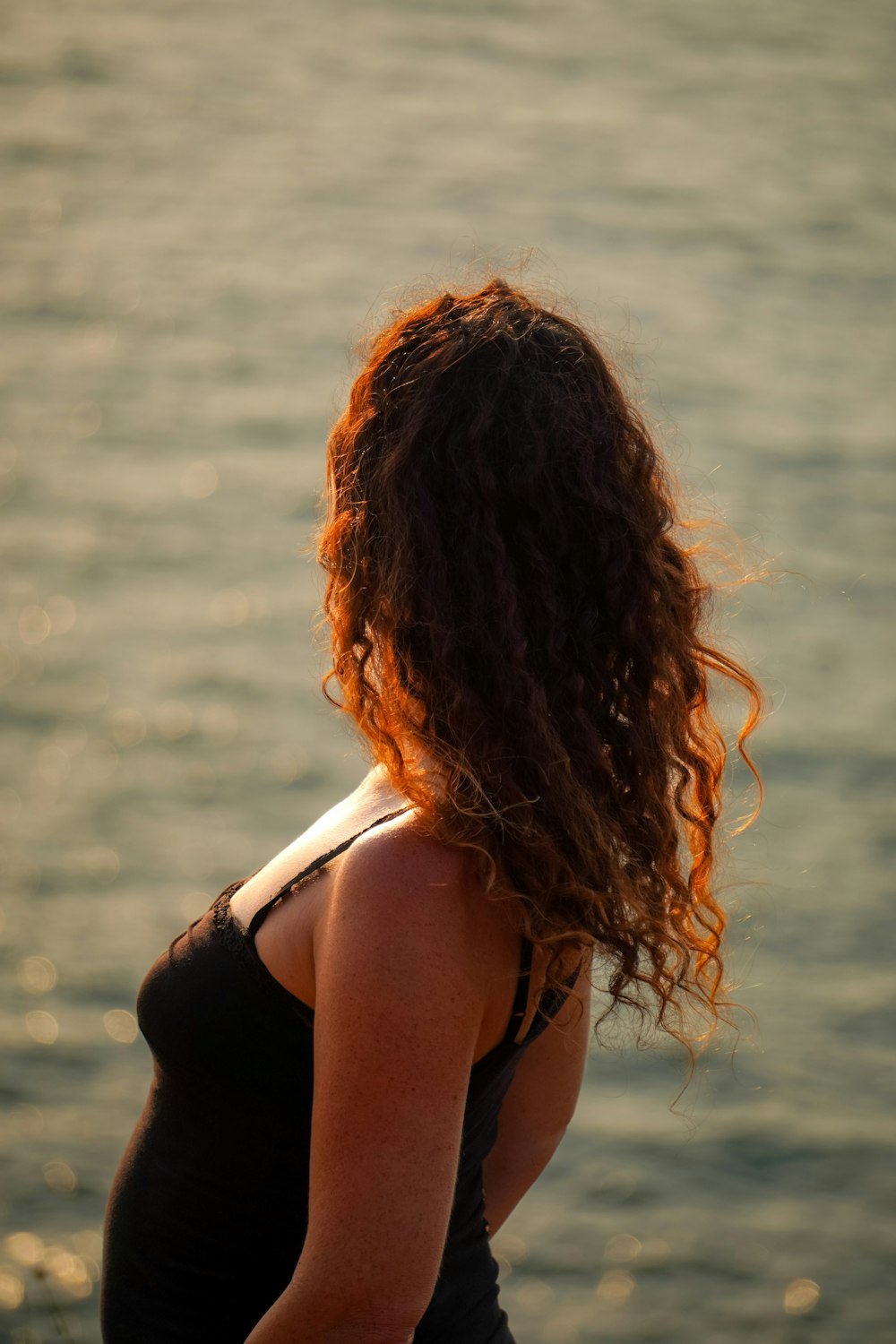 a woman standing in front of a body of water