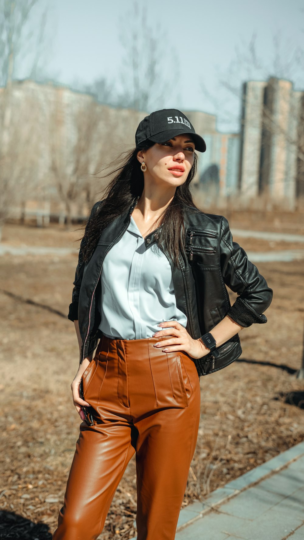 a woman wearing brown pants and a black hat