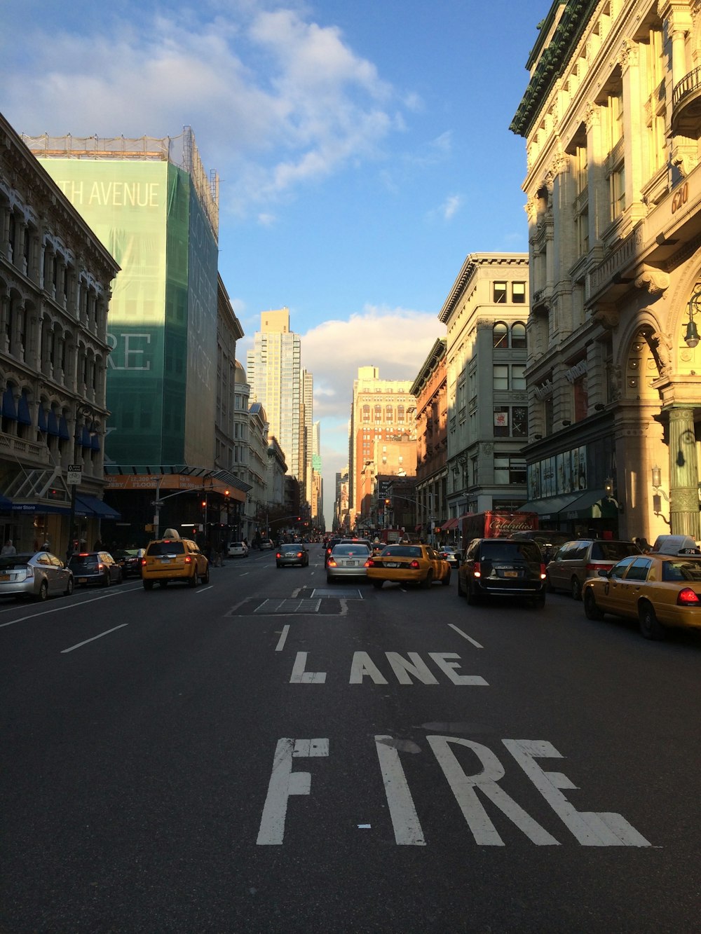 a street filled with lots of traffic next to tall buildings