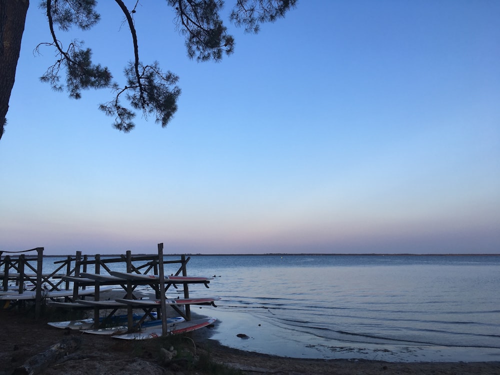 a boat sitting on top of a beach next to a tree