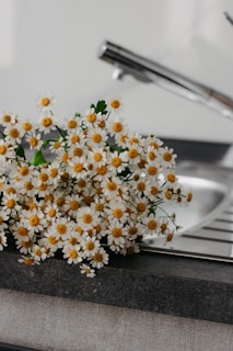 Close-up of sparkling clean kitchen countertops with a bouquet of fresh flowers adding a cozy touch.