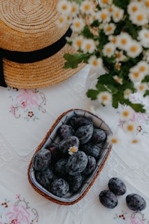 A tiny cotton cap resting on a rustic Himalayan wooden table beside fresh mountain flowers.