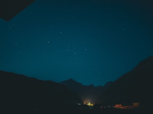 A peaceful scene of a person meditating under a starry night sky with subtle golden highlights.